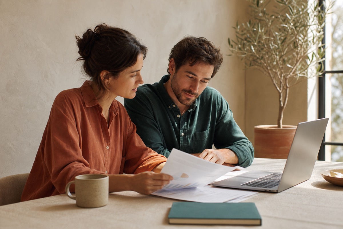 Two founders reviewing a printed forecast together at a sunlit desk